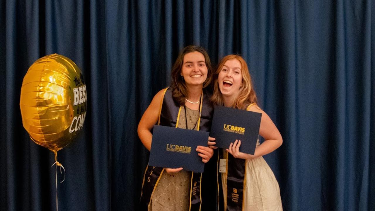 Pictured: Two students getting photographed at the end of the Spring Banquet ceremony.