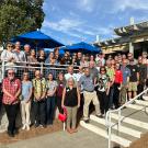 Large group of alumni gathered in front of a building